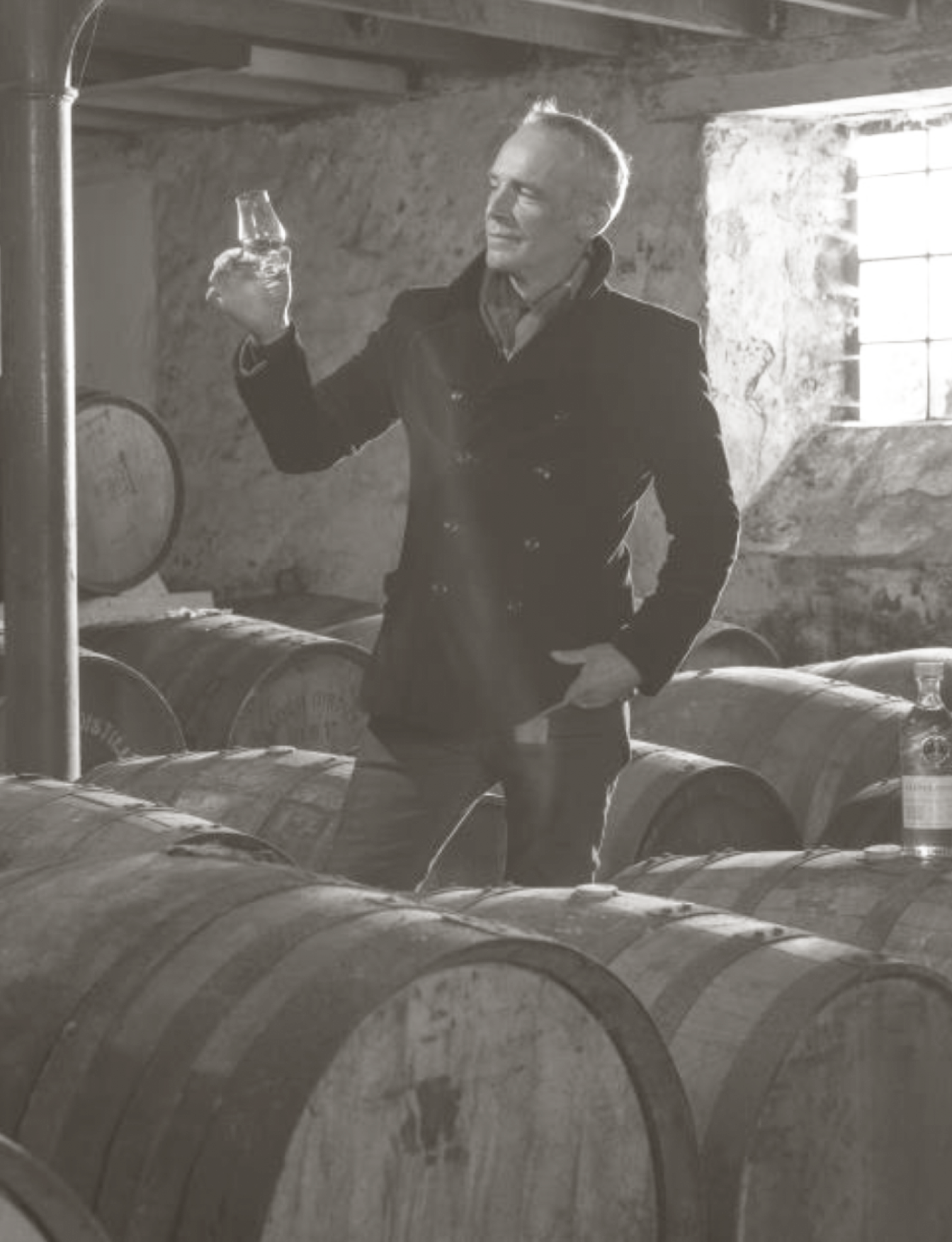 Picture of Stewart Buchanan holding up a glass of Glenglassaugh inside the distillery.